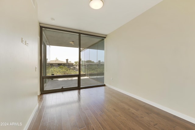 7120 E Kierland Blvd Unit 316, Scottsdale, AZ 85254 - spare room with a wall of windows, wood finished floors, and baseboards