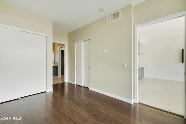 7120 E Kierland Blvd Unit 316, Scottsdale, AZ 85254 - unfurnished bedroom featuring wood finished floors, two closets, and baseboards