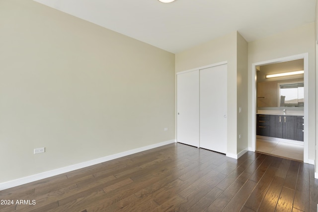 7120 E Kierland Blvd Unit 316, Scottsdale, AZ 85254 - unfurnished bedroom with dark wood-style flooring, a closet, and baseboards