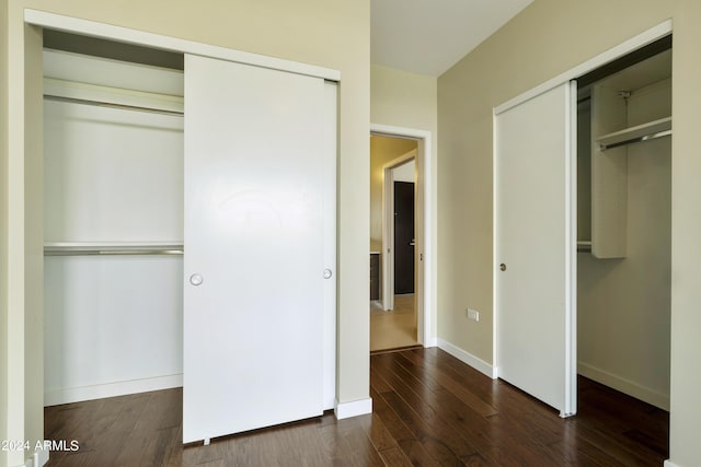 7120 E Kierland Blvd Unit 316, Scottsdale, AZ 85254 - unfurnished bedroom featuring dark wood finished floors, baseboards, and multiple closets