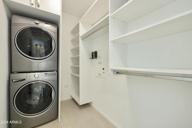 7120 E Kierland Blvd Unit 316, Scottsdale, AZ 85254 - laundry area featuring estacked washer and dryer, light tile patterned floors, and baseboards