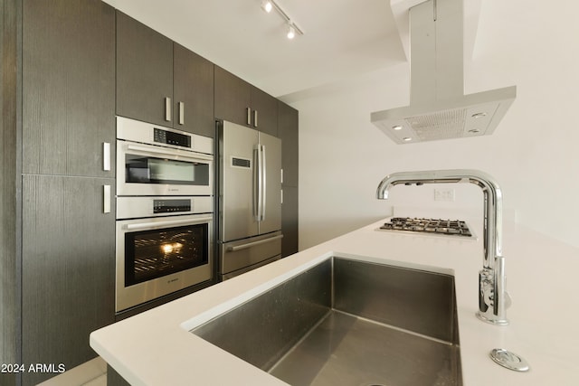 7120 E Kierland Blvd Unit 316, Scottsdale, AZ 85254 - kitchen with island exhaust hood, appliances with stainless steel finishes, light countertops, and a sink