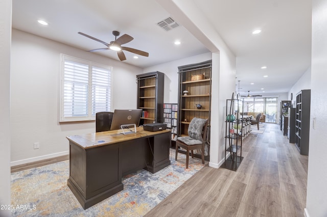 home office with recessed lighting, visible vents, baseboards, a ceiling fan, and light wood finished floors