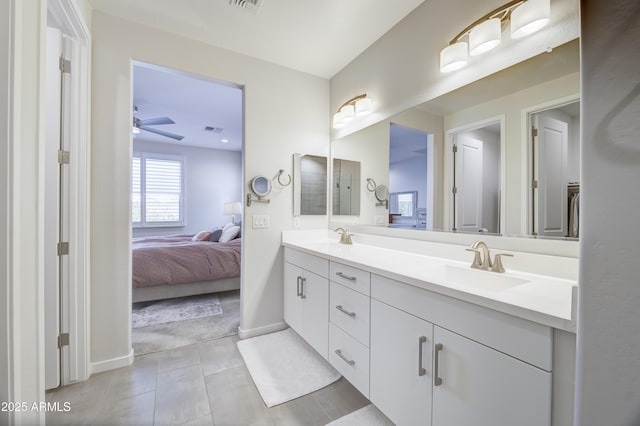 full bath featuring double vanity, connected bathroom, visible vents, and a sink