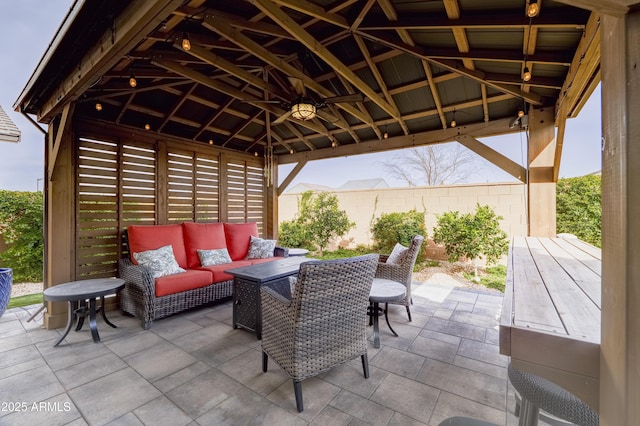 view of patio / terrace with fence, an outdoor living space, and a gazebo