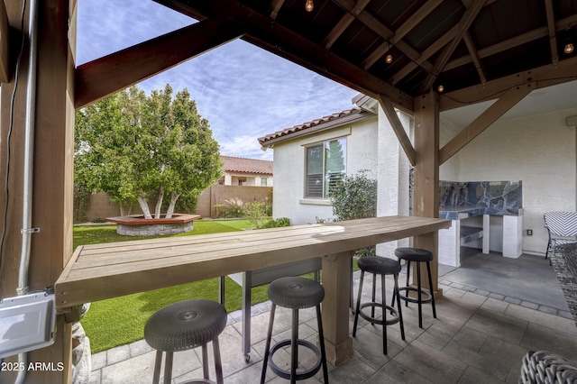 view of patio with fence and outdoor dry bar