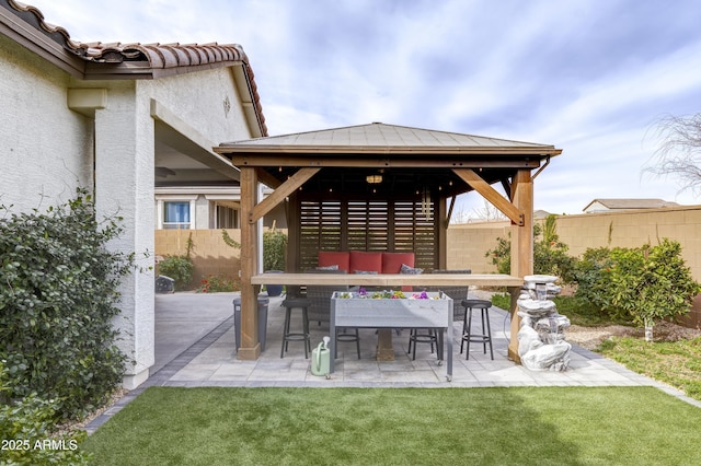 view of patio featuring a gazebo, outdoor dining space, and fence