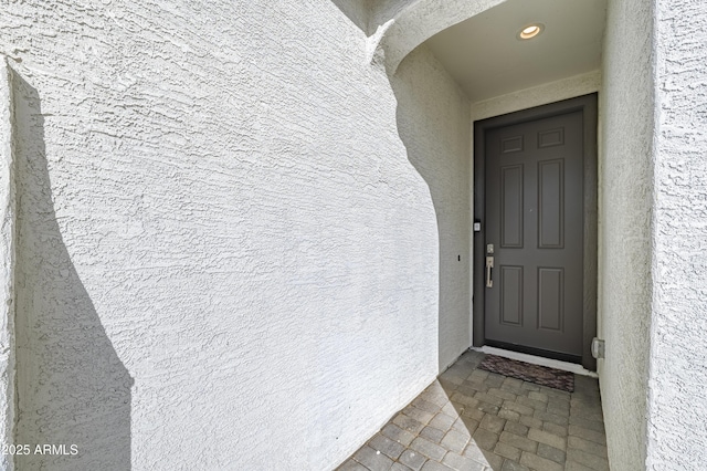 property entrance with stucco siding