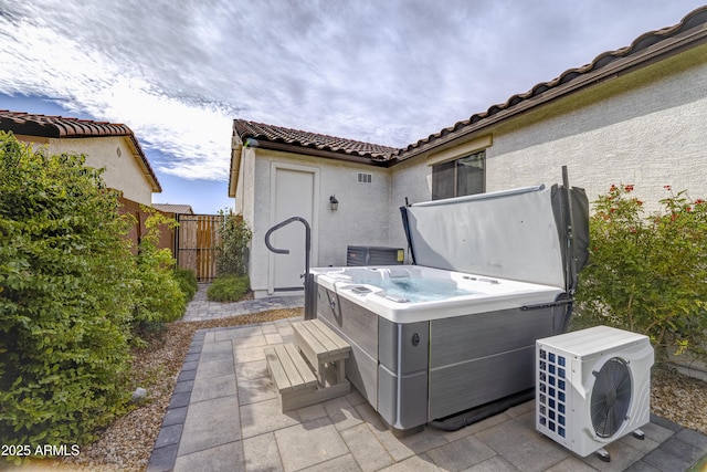 view of patio featuring fence and a hot tub