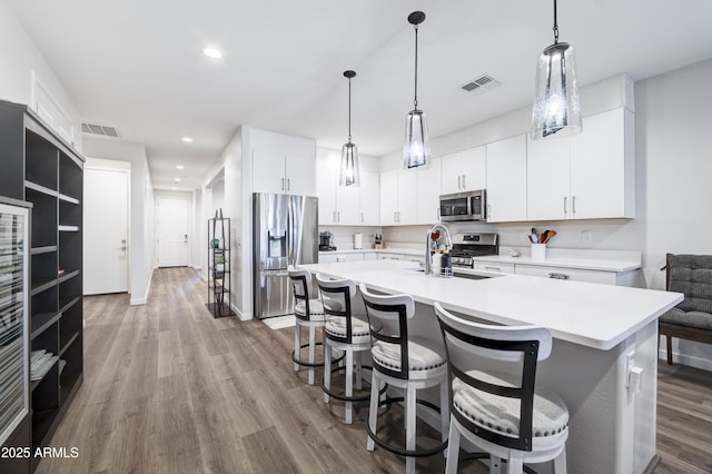 kitchen featuring visible vents, stainless steel appliances, a sink, and light countertops