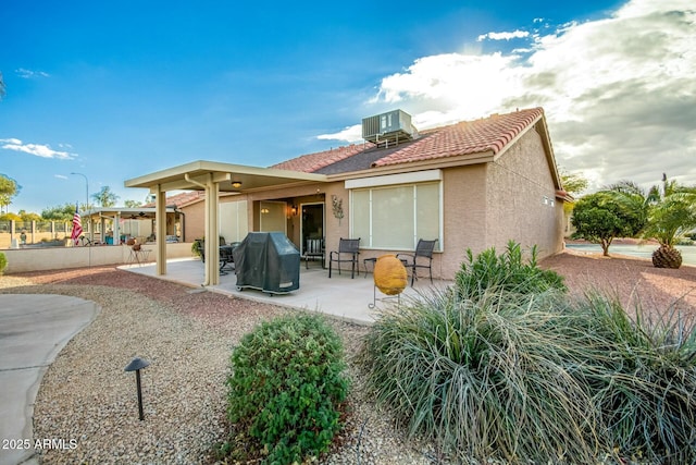 rear view of property featuring central AC unit and a patio