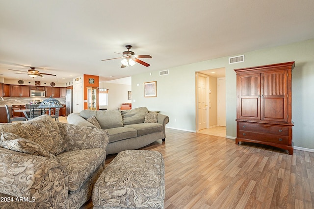 living room featuring light hardwood / wood-style flooring and ceiling fan