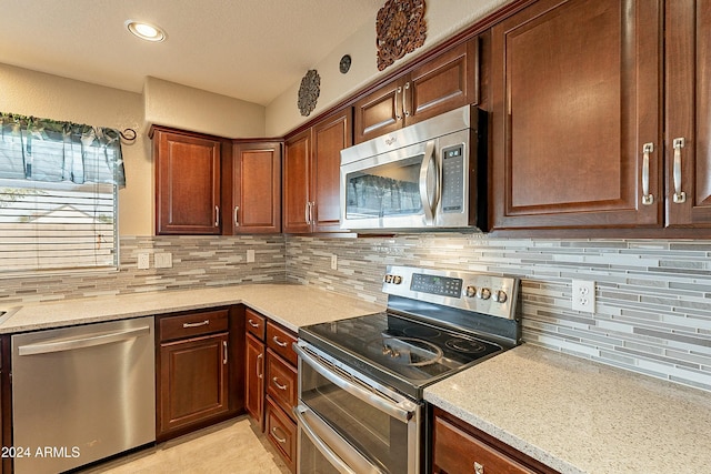 kitchen featuring backsplash, stainless steel appliances, and light stone counters