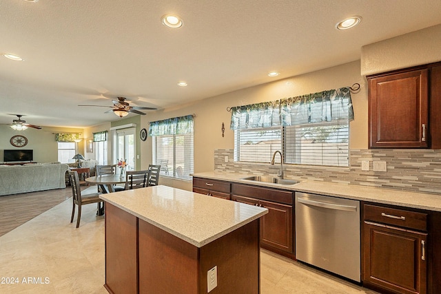 kitchen with dishwasher, a center island, sink, ceiling fan, and decorative backsplash