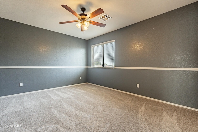 carpeted spare room featuring ceiling fan