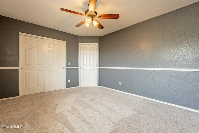 unfurnished bedroom with carpet flooring, ceiling fan, and a closet