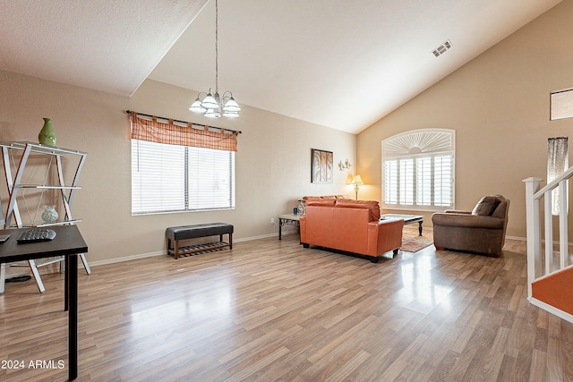 living room featuring high vaulted ceiling, a notable chandelier, and light wood-type flooring