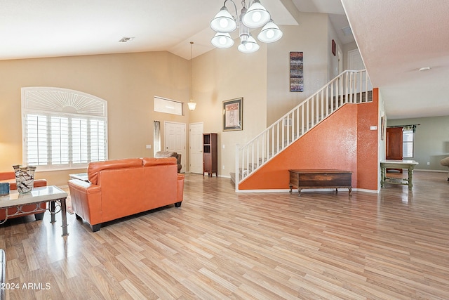 living room with a chandelier, light hardwood / wood-style floors, and high vaulted ceiling