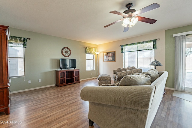 living room featuring hardwood / wood-style floors, ceiling fan, and a wealth of natural light