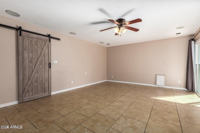 16814 N 31st Ave, Phoenix, AZ 85053 - spare room featuring light tile patterned floors, baseboards, a ceiling fan, and a barn door
