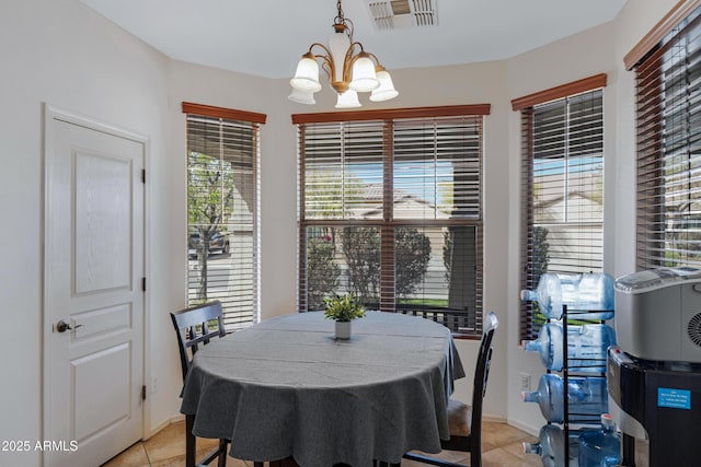 dining space with light tile patterned floors, visible vents, baseboards, and an inviting chandelier