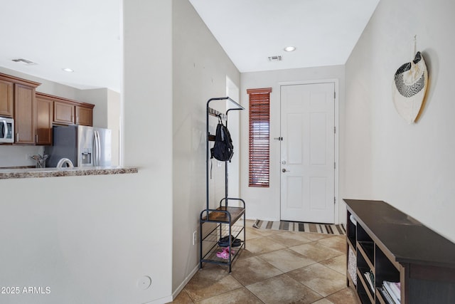 foyer with light tile patterned floors, visible vents, and recessed lighting