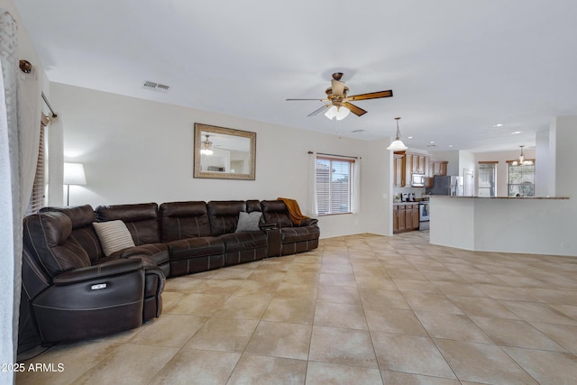 living room with ceiling fan, light tile patterned flooring, and visible vents