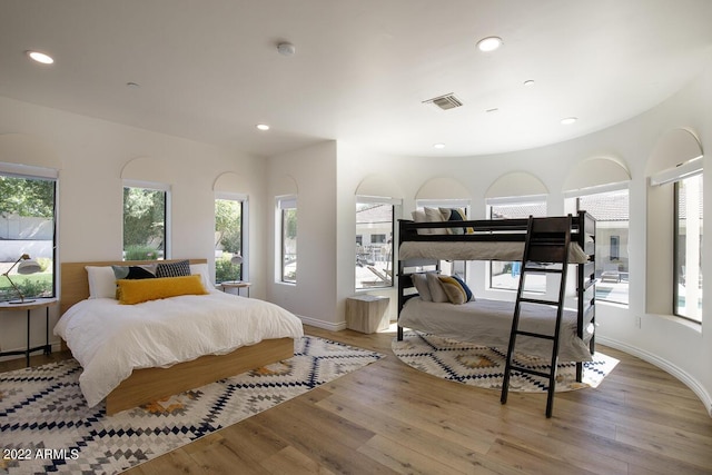 bedroom featuring baseboards, visible vents, wood finished floors, and recessed lighting