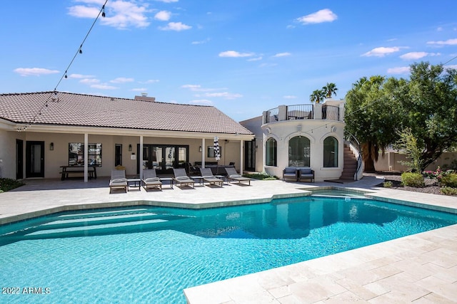 pool with french doors and a patio area