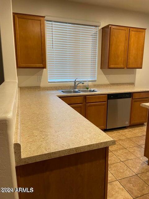 kitchen with sink, light tile patterned flooring, and dishwasher