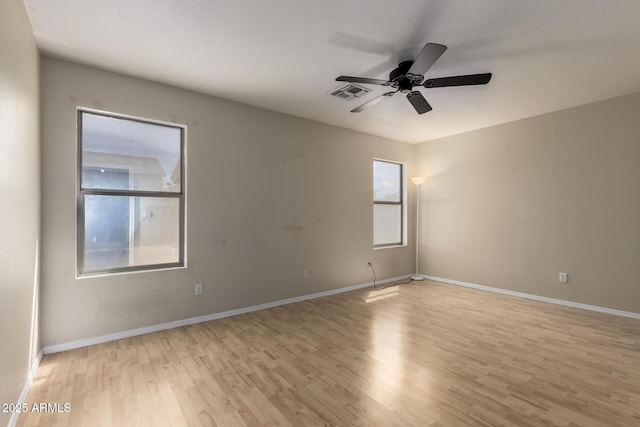 unfurnished room featuring baseboards, a ceiling fan, light wood finished floors, and visible vents
