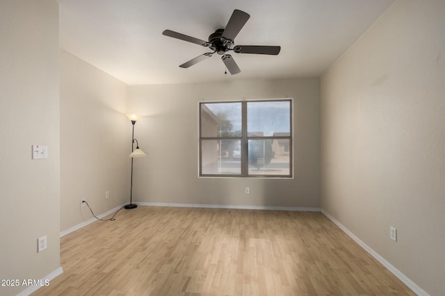 empty room featuring ceiling fan, baseboards, and light wood finished floors