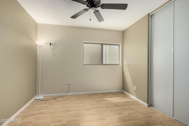 unfurnished bedroom with light wood-style floors, a ceiling fan, and baseboards