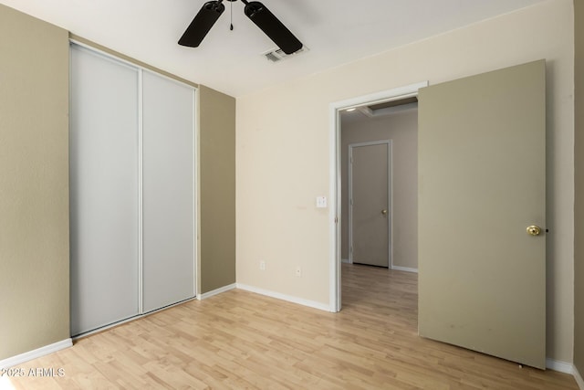 unfurnished bedroom with light wood finished floors, baseboards, visible vents, and a closet
