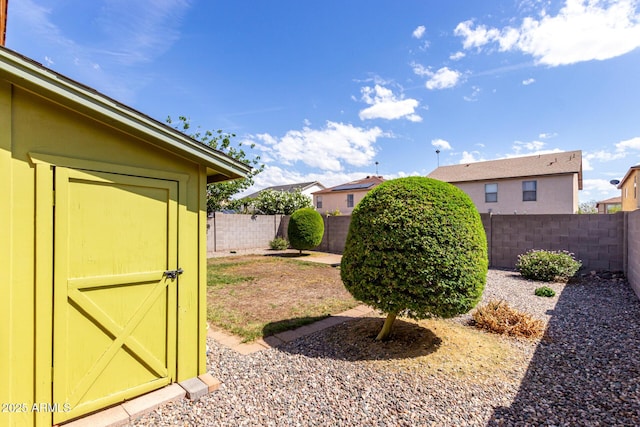view of yard featuring a fenced backyard, an outbuilding, and a shed