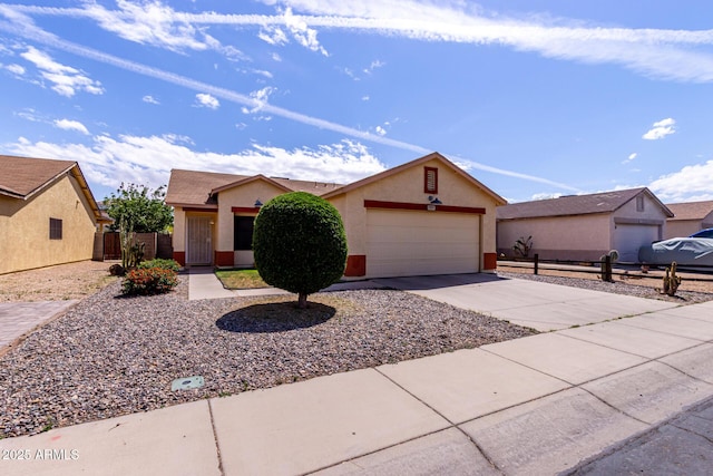 ranch-style house featuring an attached garage, driveway, stucco siding, and fence