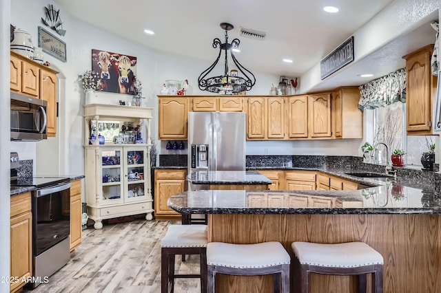 kitchen featuring pendant lighting, sink, a breakfast bar area, light hardwood / wood-style flooring, and stainless steel appliances