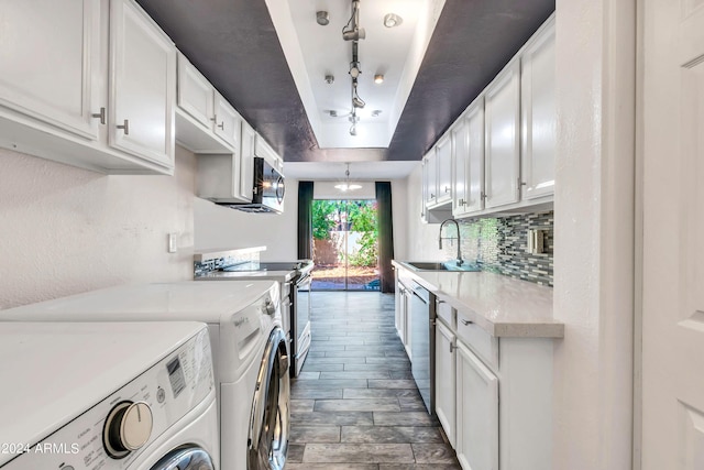 kitchen with white cabinetry, a sink, light countertops, a raised ceiling, and appliances with stainless steel finishes