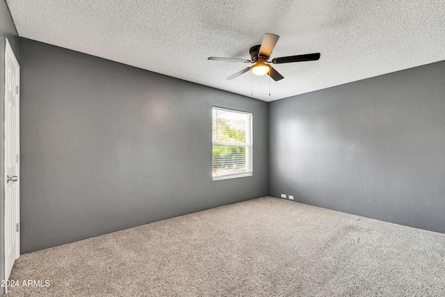 spare room featuring carpet flooring, a textured ceiling, and ceiling fan