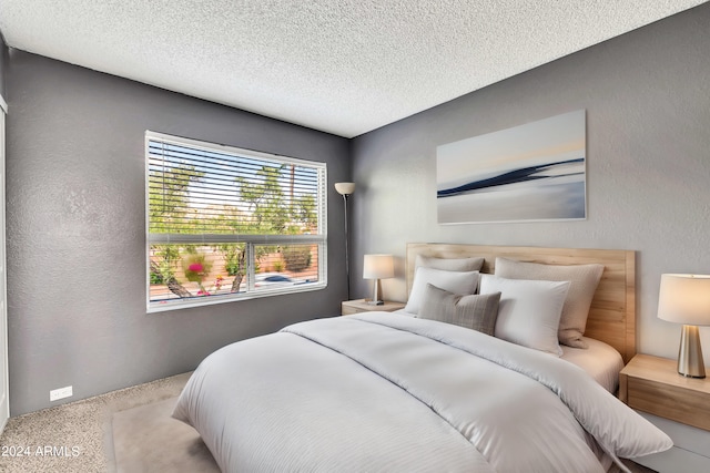 bedroom with a textured ceiling and a textured wall