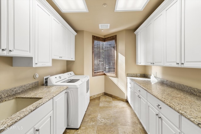 laundry room with washer and dryer and cabinets