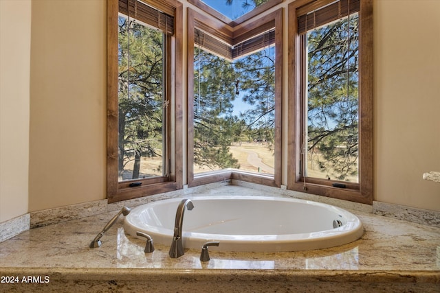 bathroom with a wealth of natural light and tiled tub