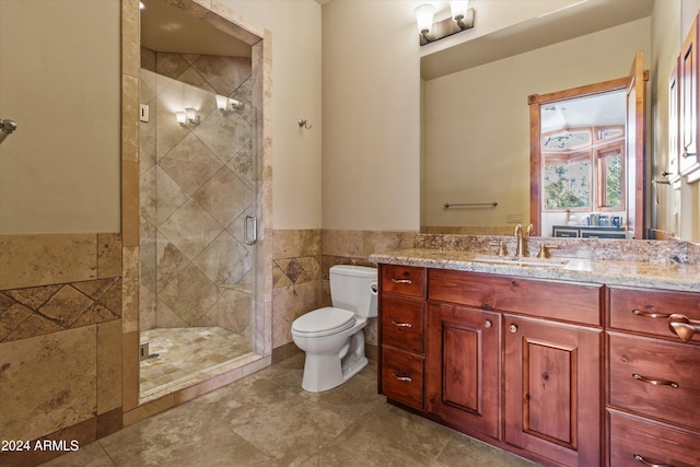 bathroom featuring walk in shower, vanity, tile walls, tile patterned flooring, and toilet