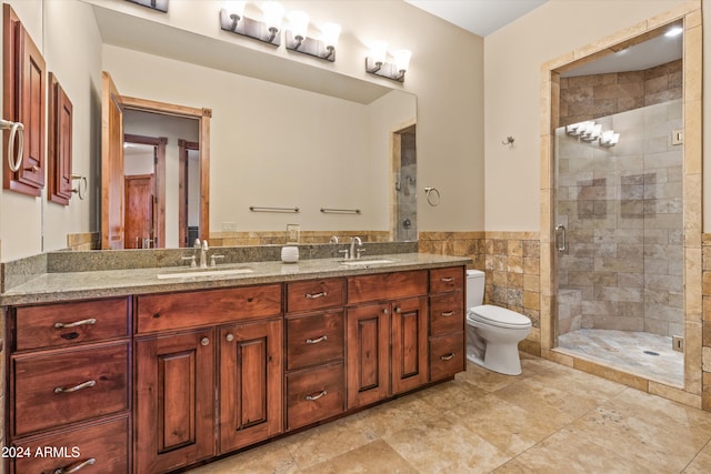 bathroom featuring an enclosed shower, vanity, toilet, and tile walls