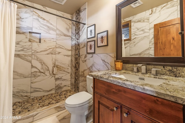 bathroom featuring toilet, vanity, tile walls, and a shower with shower curtain