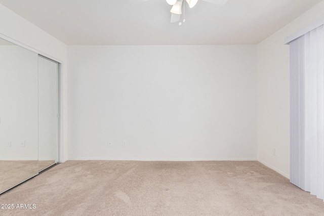 unfurnished bedroom with ceiling fan, light colored carpet, and a closet