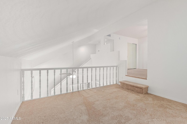 additional living space featuring vaulted ceiling and carpet flooring