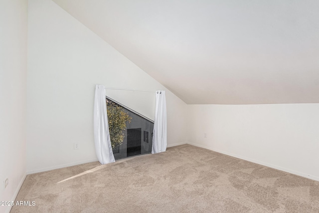 unfurnished living room featuring light colored carpet and vaulted ceiling