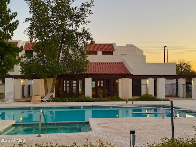 pool at dusk with a patio