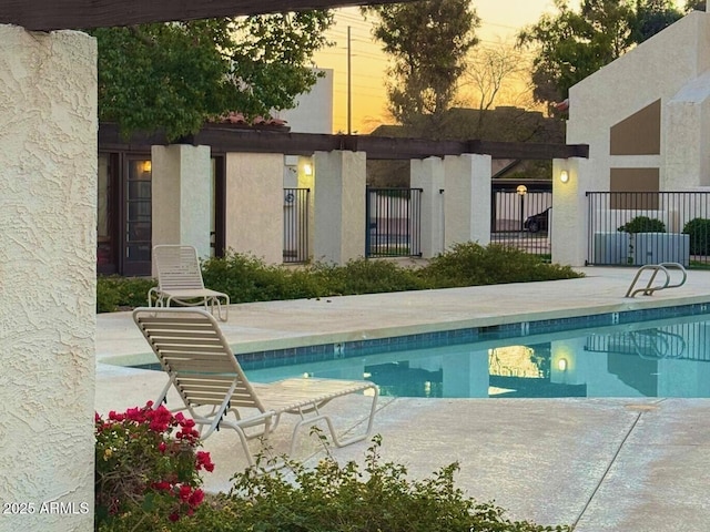 pool at dusk featuring a patio area